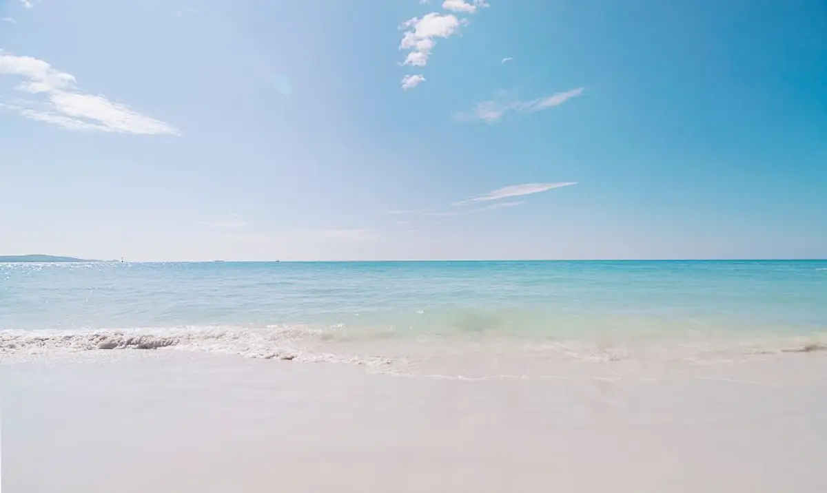 Voyage en Asie — Plage de Pantai Pasir Putih à Bali avec son sable blanc et ses eaux turquoise bordées de végétation tropicale.