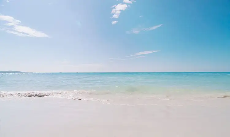 Voyage en Asie — Plage de Pantai Pasir Putih à Bali avec son sable blanc et ses eaux turquoise bordées de végétation tropicale.