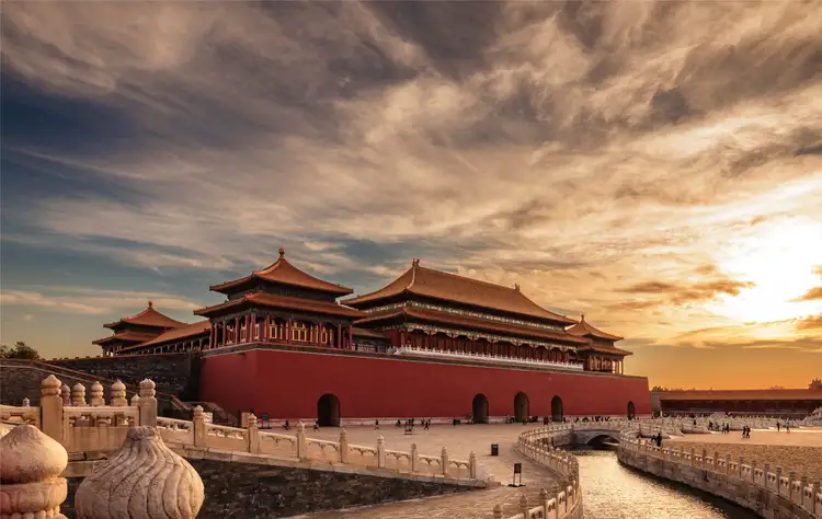 Coucher de soleil doré sur les pavillons et toits traditionnels de la Cité Interdite à Pékin.