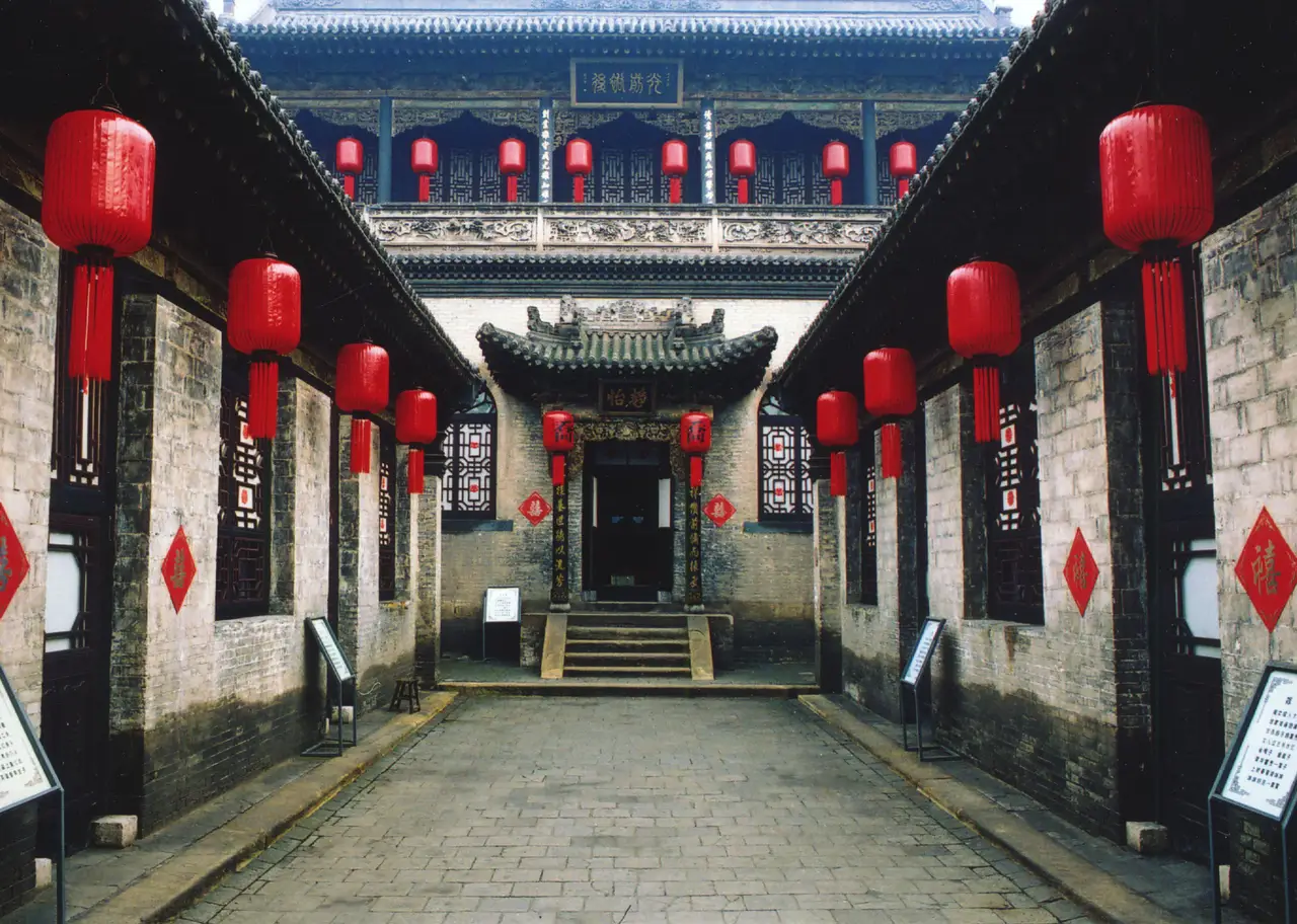 Cour intérieure symétrique de la résidence de la famille Qiao avec des rangées de lanternes rouges suspendues près de Pingyao.