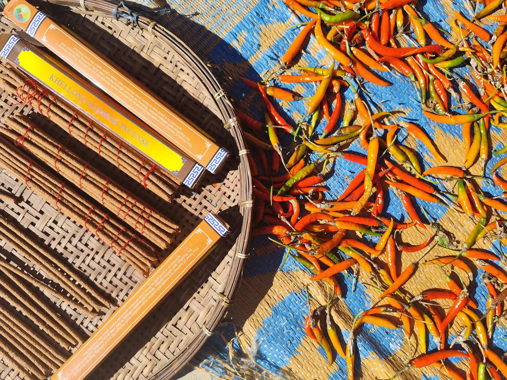 Travel in Asia - Chili peppers drying in the sun next to a basket
