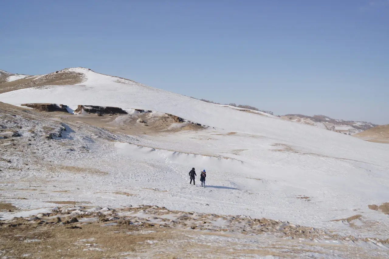 Deux marcheurs sur une steppe enneigée