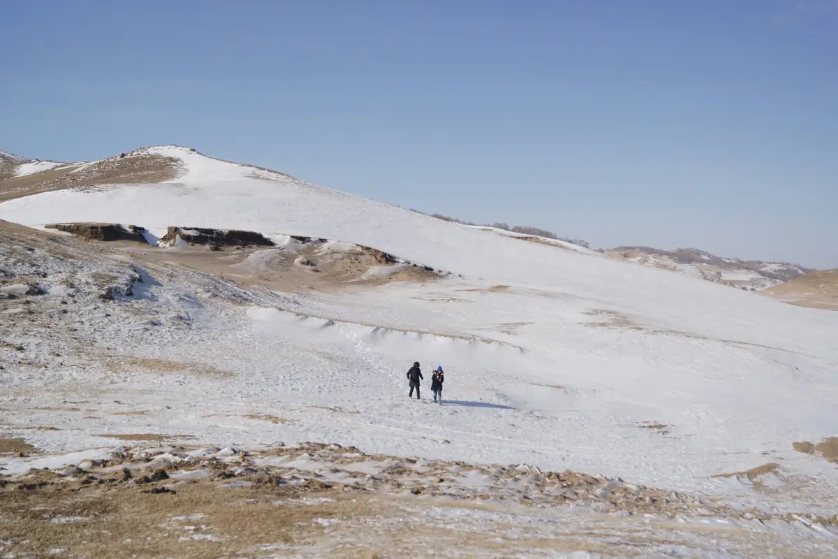 Deux marcheurs sur une steppe enneigée