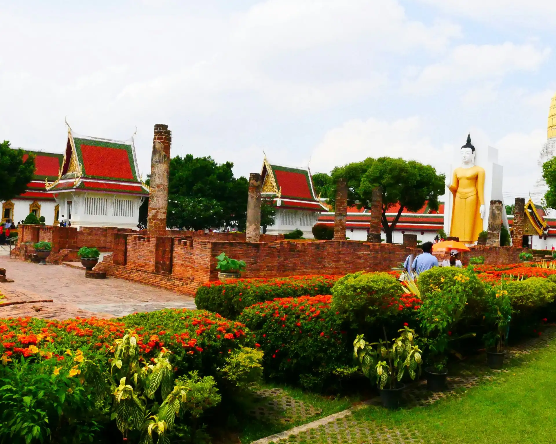 Jardins verdoyants et temples traditionnels avec une statue de Bouddha à Phitsanulok en Thaïlande.