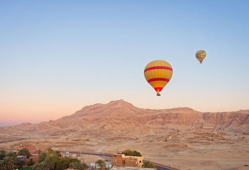 Voyage en Egypte - Vue panoramique sur des montgolfières survolant des monts égyptiens