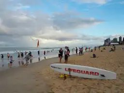 Une planche de sauvetage sur une plage de la Gold Coast, illustrant les essentiels à emporter pour la côte australienne.
