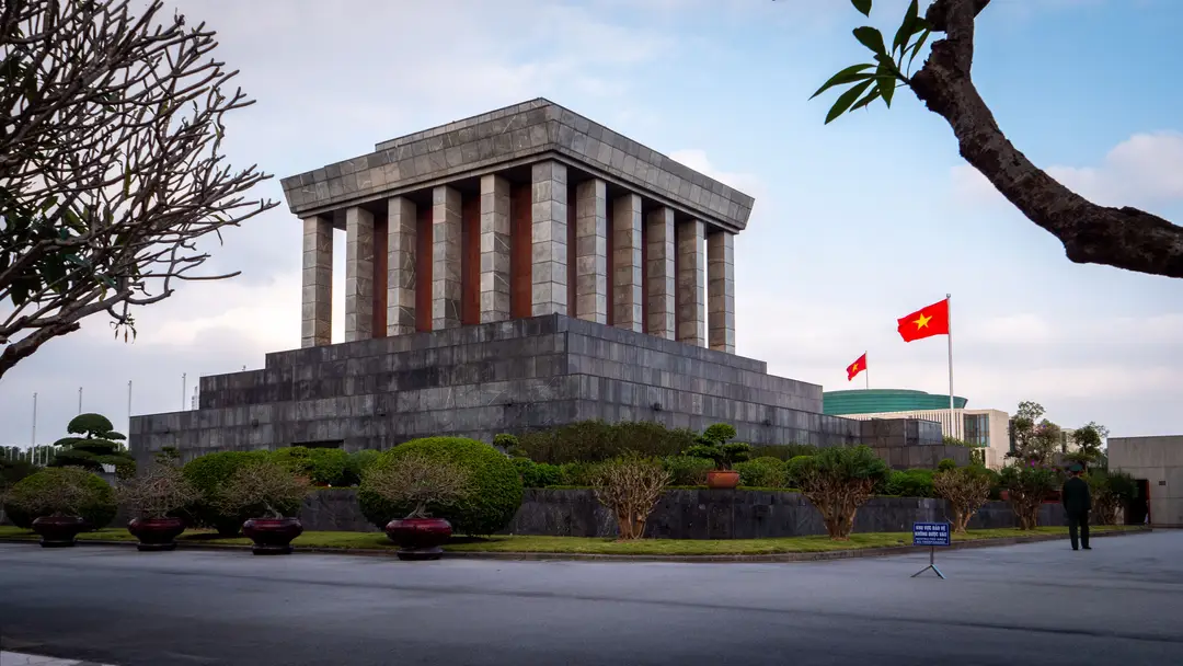 Vue imposante du Mausolée d'Ho Chi Minh à Hanoï, un lieu de mémoire national entouré de jardins soignés.