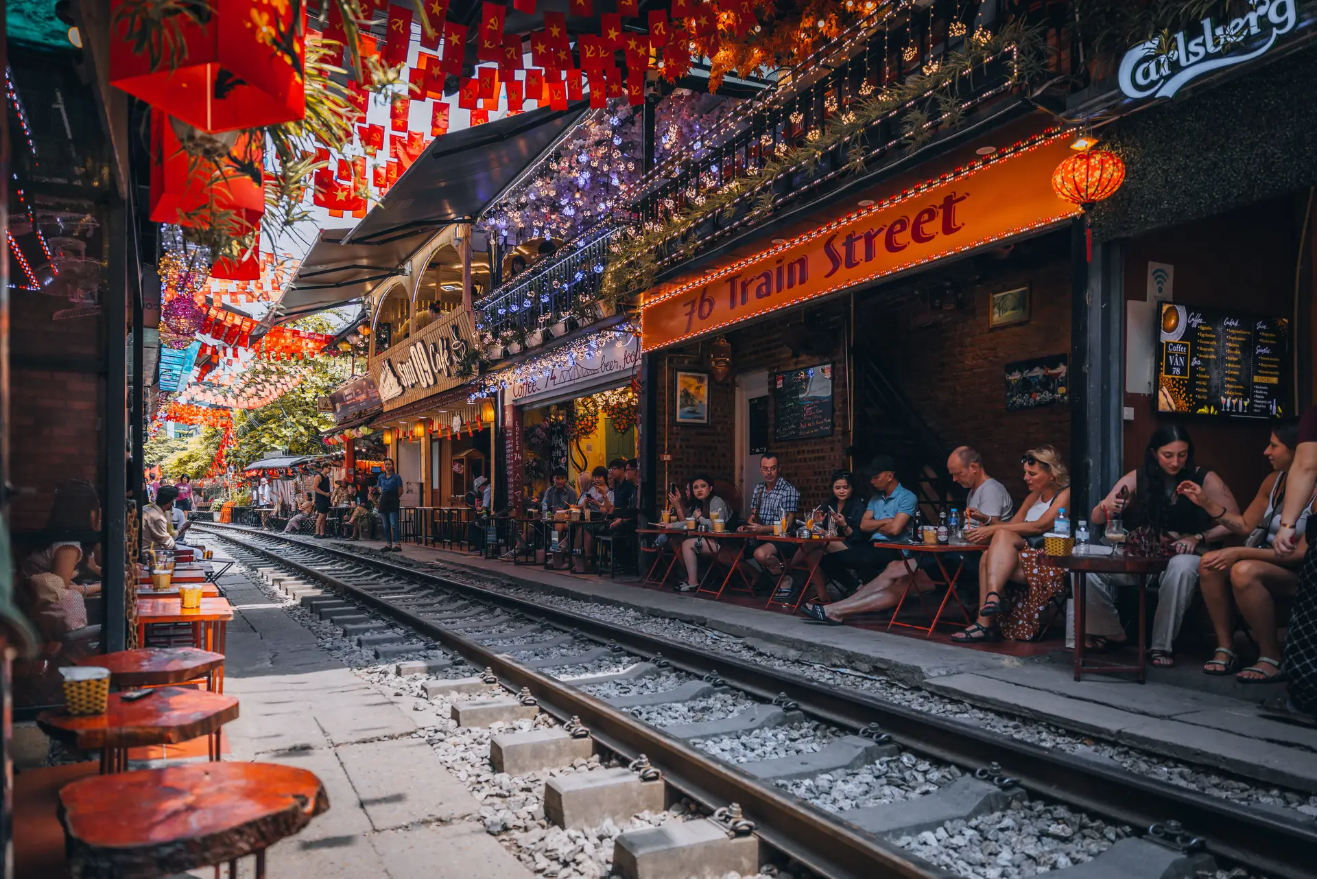 Les terrasses animées des cafés installés le long de la célèbre et étroite rue du train à Hanoi, décorée de lampions rouges au Vietnam.