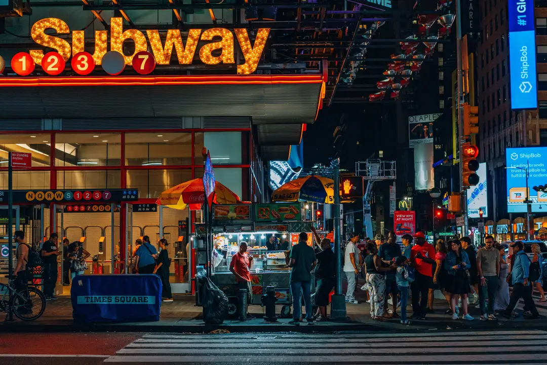 Entrée du métro de Times Square illuminée par les néons