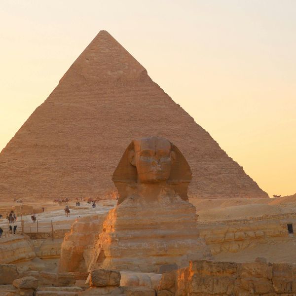 Le sphinx et une pyramide de Gizeh au coucher du soleil en Egypte