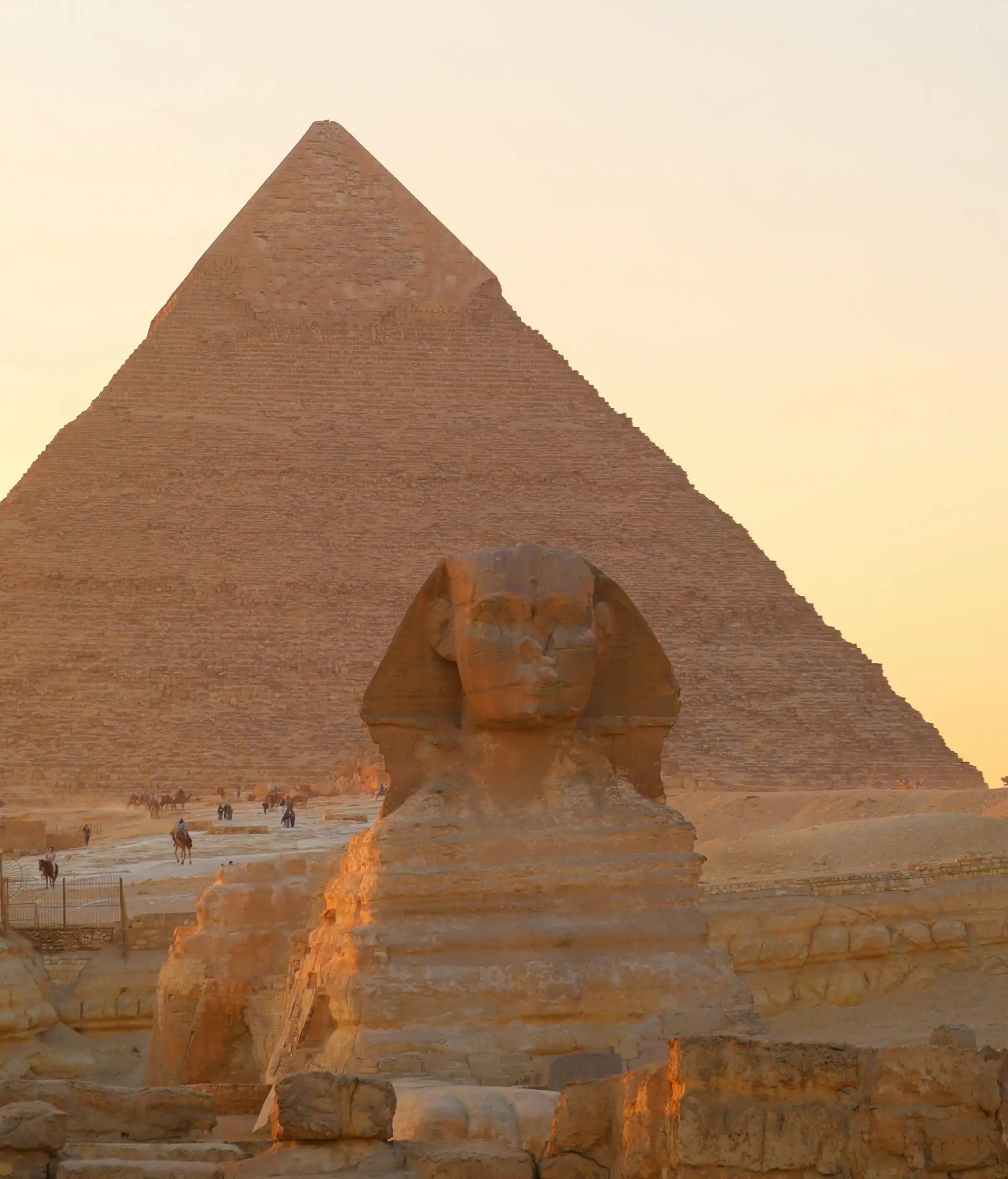 Le sphinx et une pyramide de Gizeh au coucher du soleil en Egypte