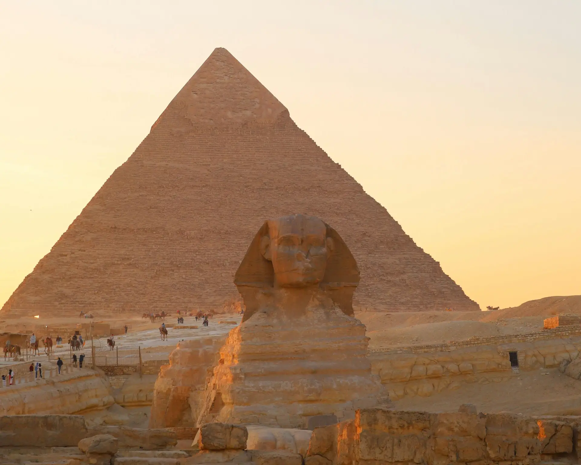 Le sphinx et une pyramide de Gizeh au coucher du soleil en Egypte