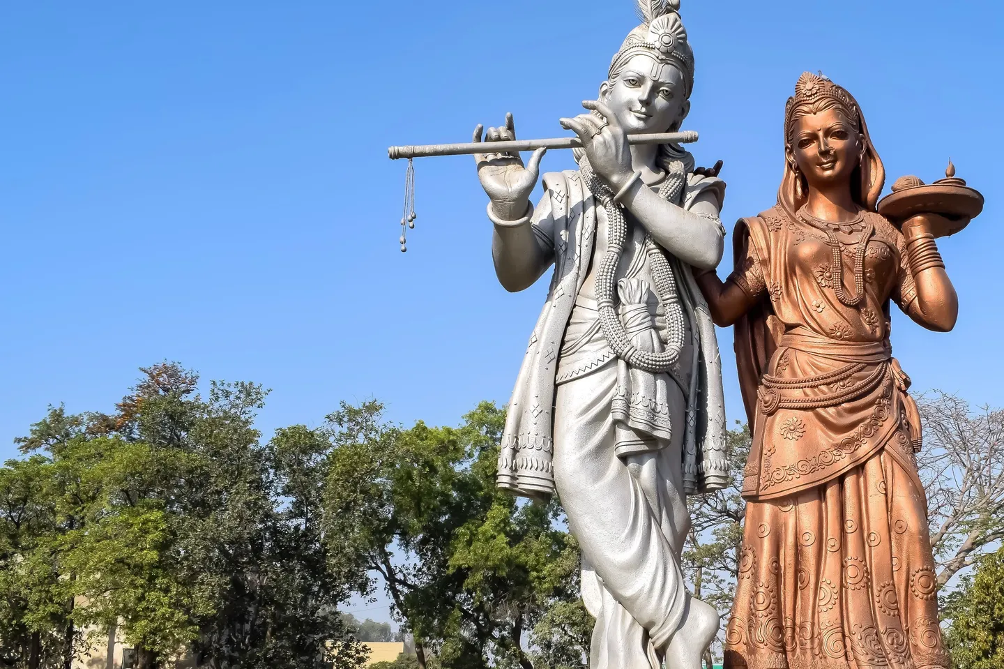 voyage en Inde - Statues de Krishna et Radha symbolisant l'amour divin sous un ciel pur.