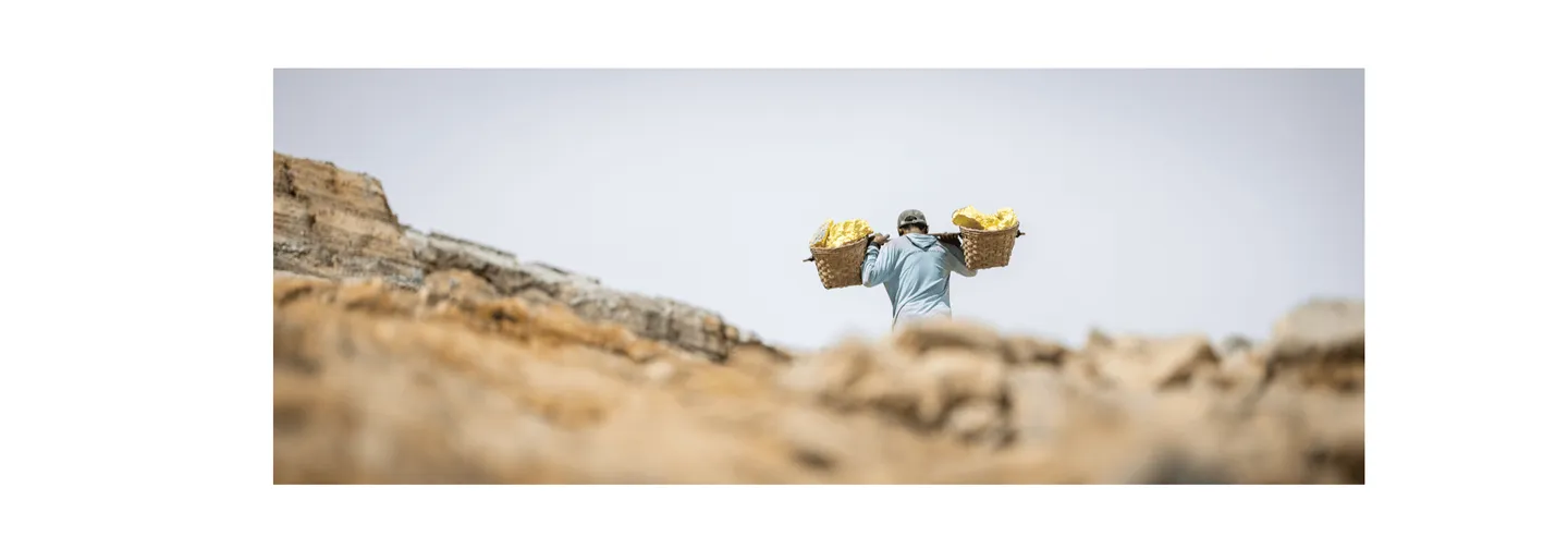 Voyage en Indonésie - Porteur de soufre du Mont Ijen vu de dos, transportant sa charge et disparaissant à l'horizon Voyage en Indonésie - Porteur de soufre du Mont Ijen vu de dos, transportant sa charge et disparaissant à l'horizon