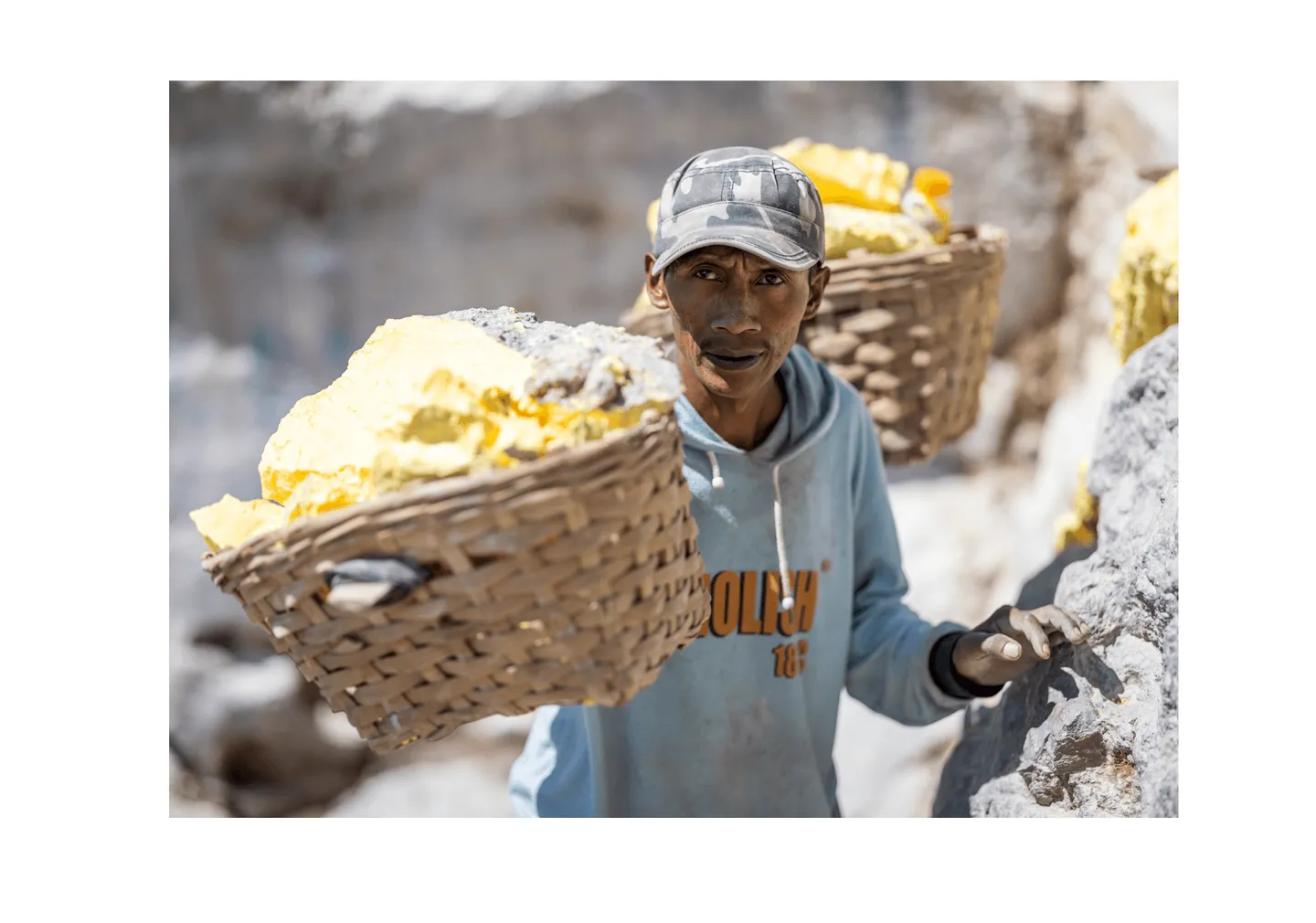 Voyage en Indonésie - portrait d'un porteur de soufre du Mont Ijen transportant sa charge sur un sentier rocheux