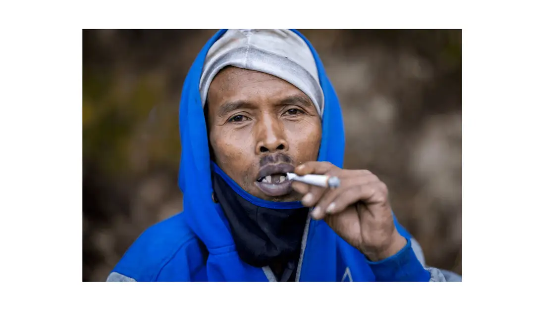 Voyage en Indonésie - portrait d'un porteur de soufre sur le Mont Ijen, fumant une cigarette