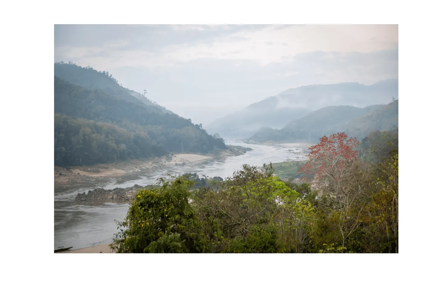 Voyage au Laos - aube sur le Mékong enveloppée de brume légère créant une atmosphère mystique