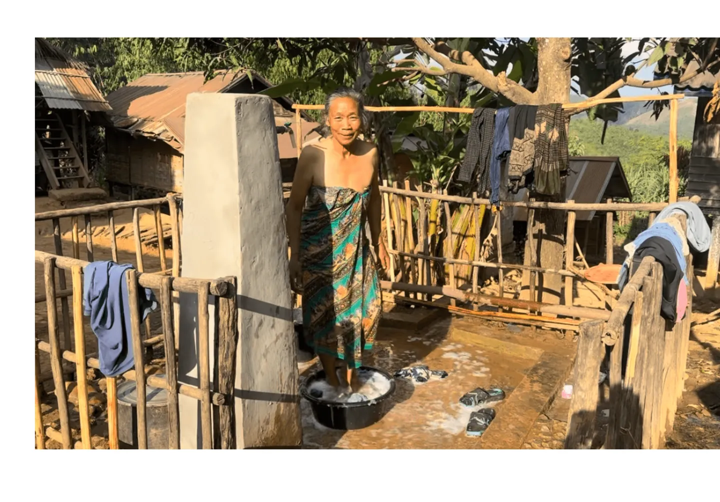 Voyage au Laos - Femme bénéficiant avec bonheur de l'eau potable acheminée directement dans les communautés par NK Seeds