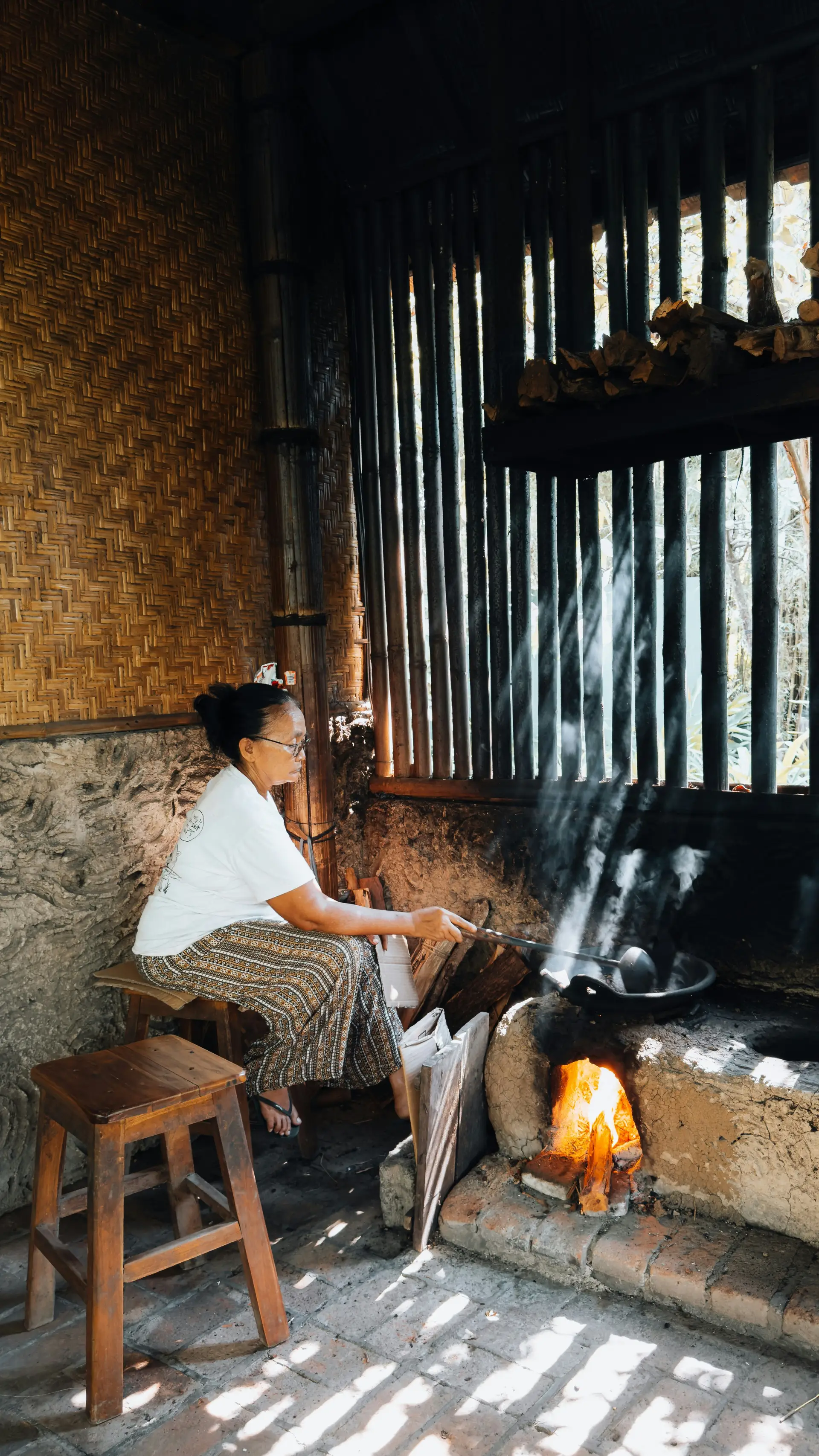 Voyage en Asie — Femme dans une cuisine traditionnelle indonésienne, scène de vie locale