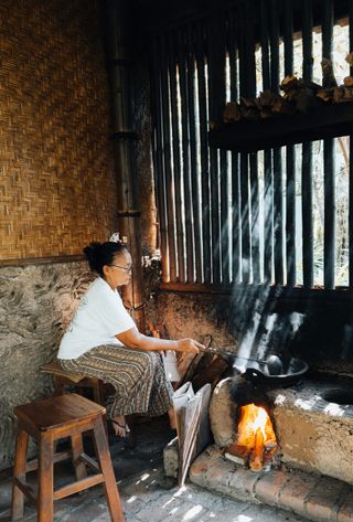 Voyage en Asie — Femme dans une cuisine traditionnelle indonésienne, scène de vie locale