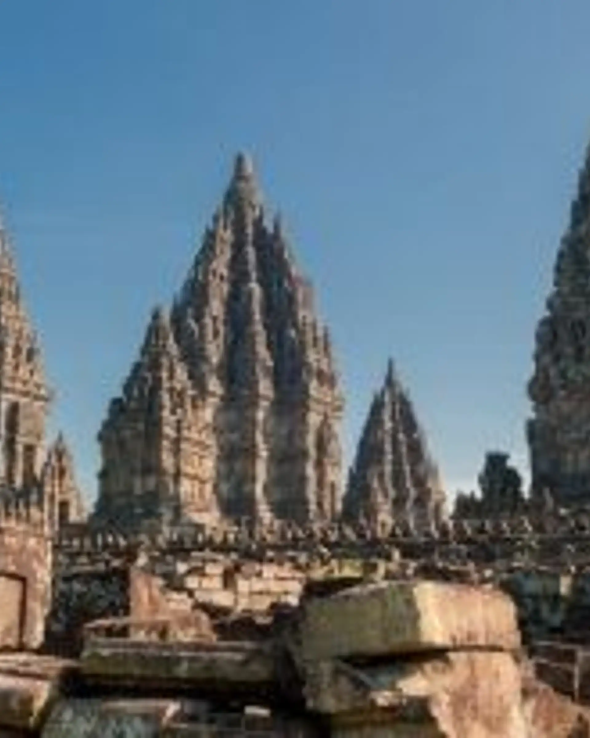 Voyage en Asie — Temples hindous de Prambanan à Java, Indonésie : tours sanctuaires en pierre et ruines sous un ciel bleu clair.