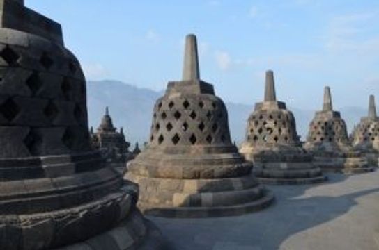 Voyage en Asie — Stupas de Borobudur à Java, Indonésie : cloches de pierre avec motifs ajourés et statues de Bouddha à l'intérieur.