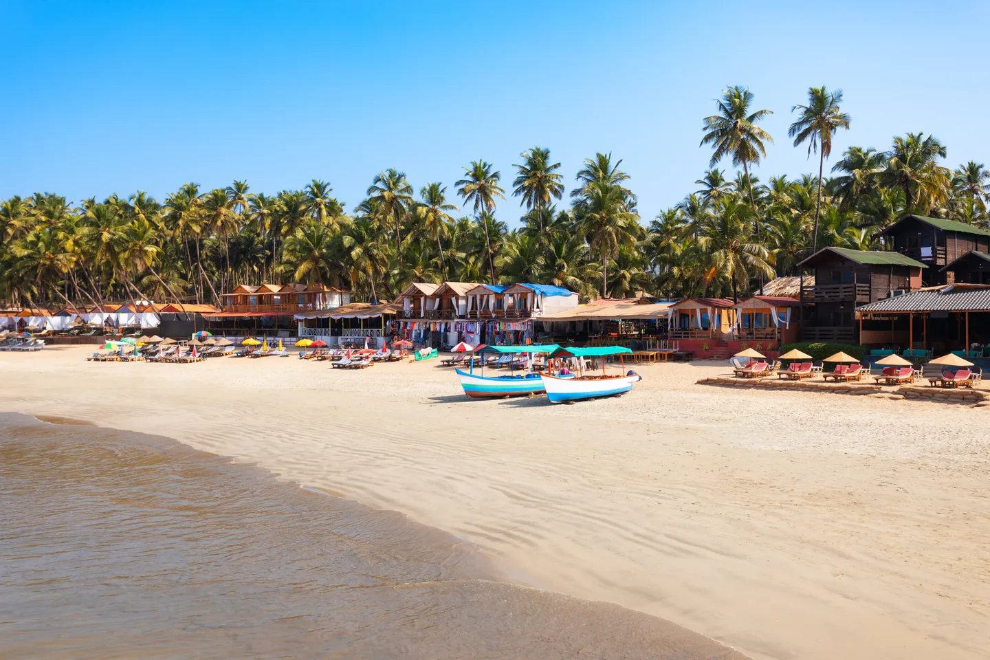Plage de Palolem à Goa bordée de cocotiers et baie en croissant idéale pour baignade et yoga au lever du soleil