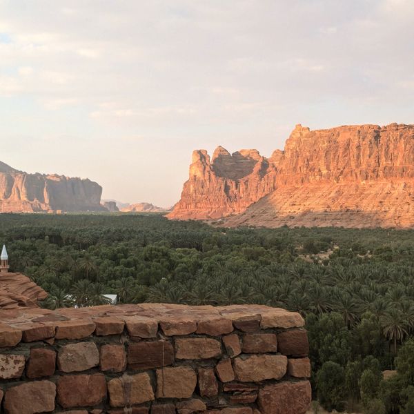 Voyage en Arabie Saoudite - Coucher de soleil sur la forteresse et les palmiers à Al Ula