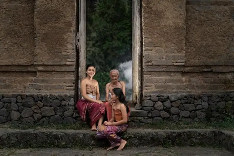 Balinesische Frauen sitzen vor einer Fassade in Bali
