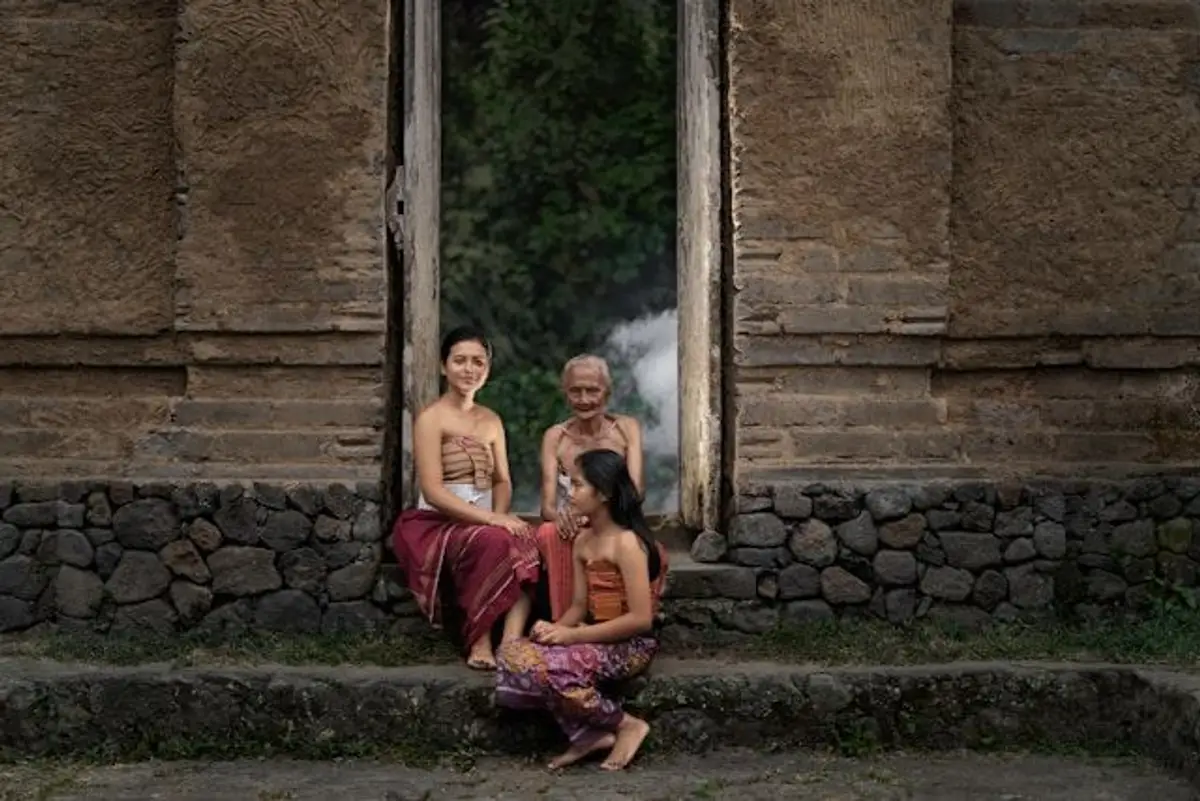 Balinesische Frauen sitzen vor einer Fassade in Bali