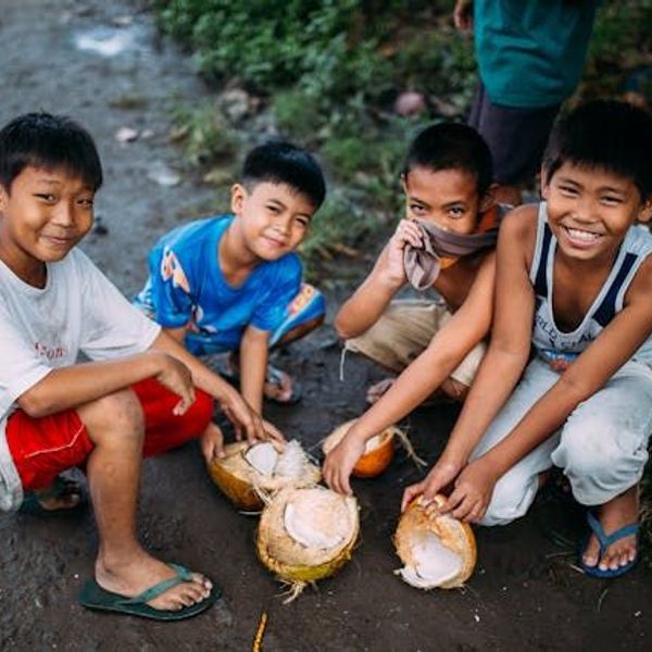 Philippino Kinder halten Kokosnüssen in den Händen