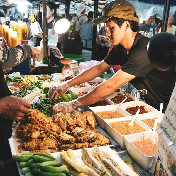 Travel in Asia - Vendor arranging food at a night market stall in Bali