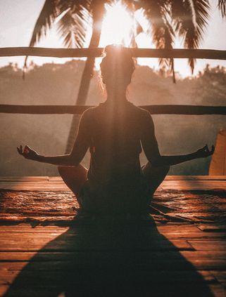 Voyage en Asie : femme méditant face à la jungle, lumière douce et atmosphère propice au recentrage intérieur.