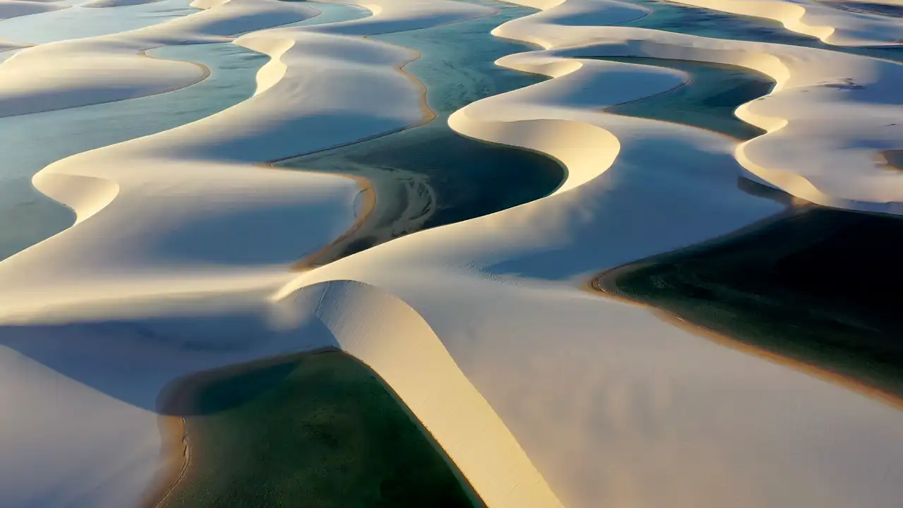 Voyage au Brésil – Vue aérienne panoramique sur le désert de dunes de sable blanc et les lagunes d'eau douce turquoise du parc national des Lençóis Maranhenses.