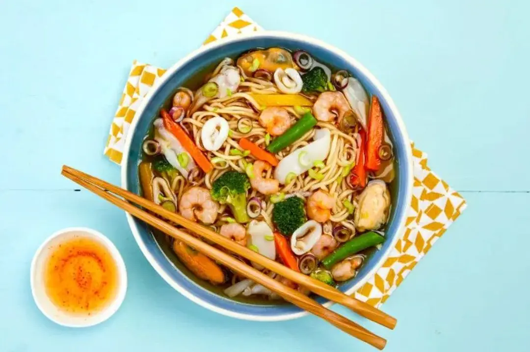 Bol de soupe vietnamienne Bun Hai San, une spécialité de nouilles de riz aux fruits de mer garnie de crevettes et de calamars.