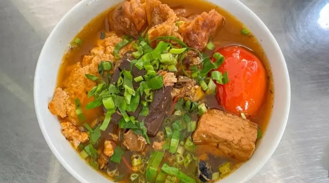 Bol de soupe traditionnelle vietnamienne Bun Rieu, une spécialité locale de Hanoï parfumée au crabe et à la tomate.