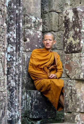 Voyage au Cambodge : Moine assis sur les marches d'un temple