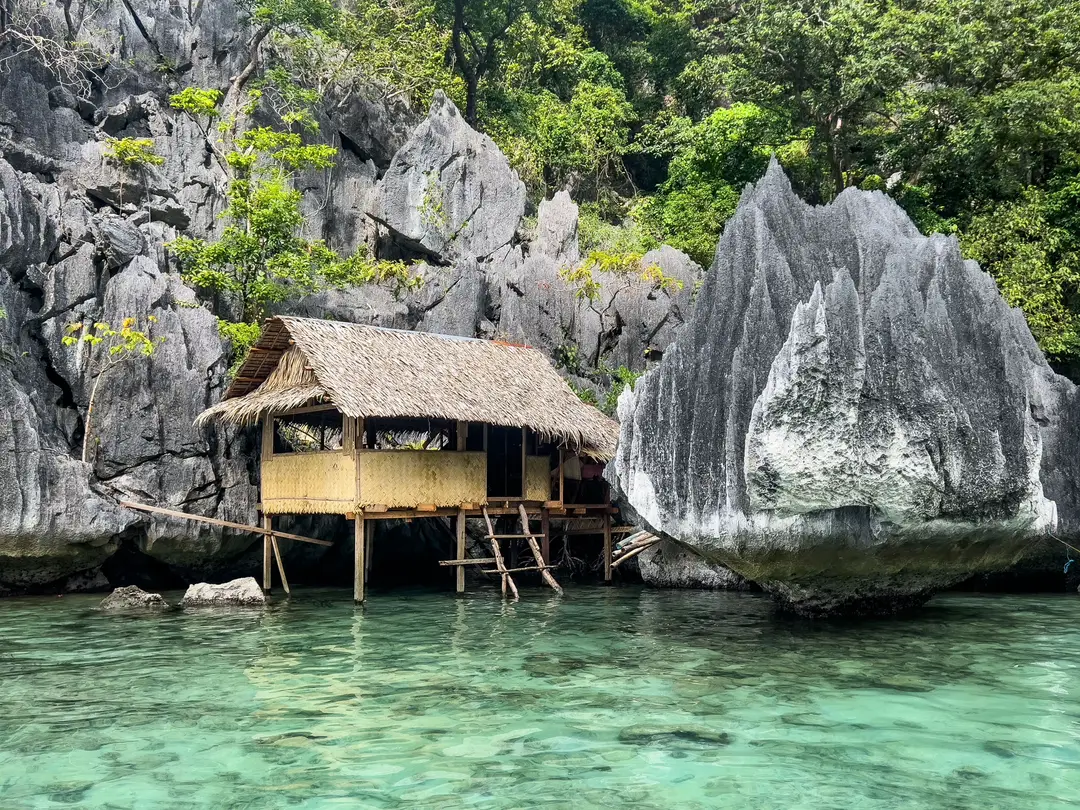 Cabane en bambou tranquille au bord d'eaux claires au milieu de falaises calcaires à Coron, aux Philippines.jpg