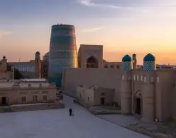 Vue panoramique de la cité fortifiée d'Itchan Kala à Khiva au coucher du soleil avec le minaret inachevé Kalta Minor en céramique bleue.