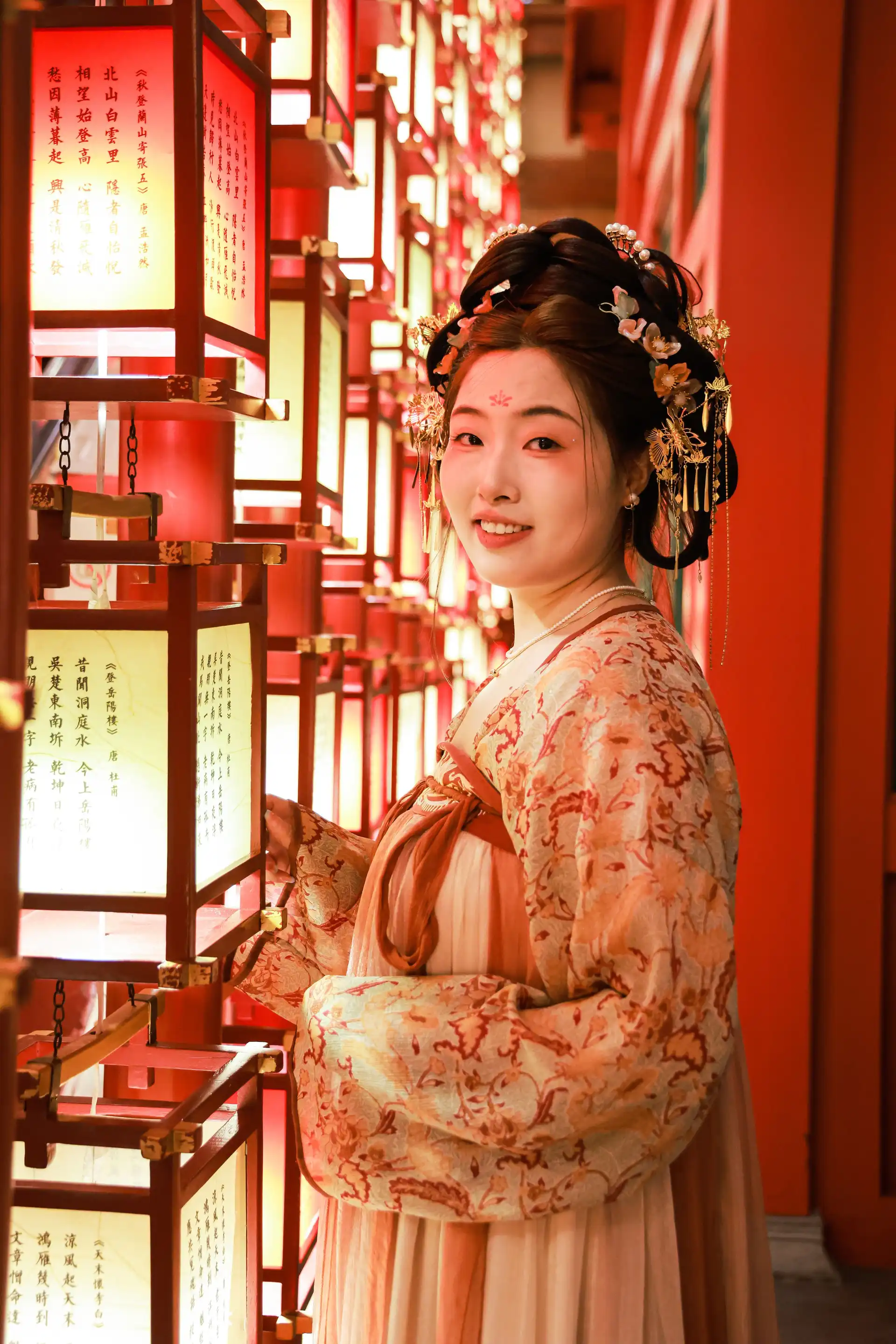 Voyage en Chine – Femme en tenue traditionnelle hanfu souriante devant des lampions rouges lumineux à Xi'an.