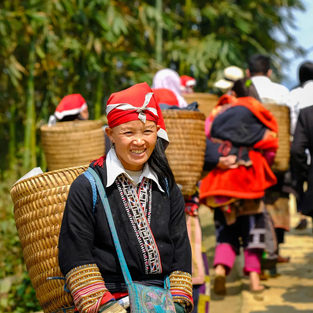 Dao rouges en tenue traditionnelle avec des paniers, en plein air à Lào Cai, au Vietnam.jpg