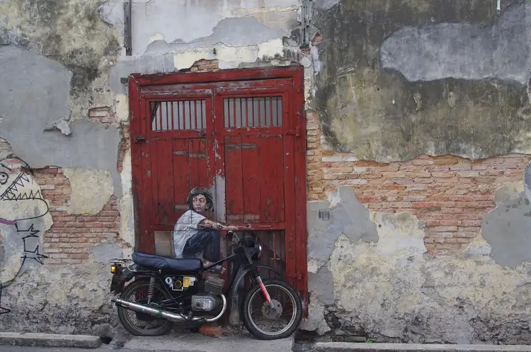Détail d'une porte rouge traditionnelle dans une façade historique patinée au cœur de Georgetown, Penang.
