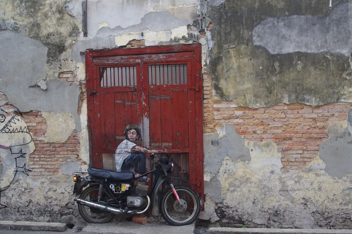 Détail d'une porte rouge traditionnelle dans une façade historique patinée au cœur de Georgetown, Penang.