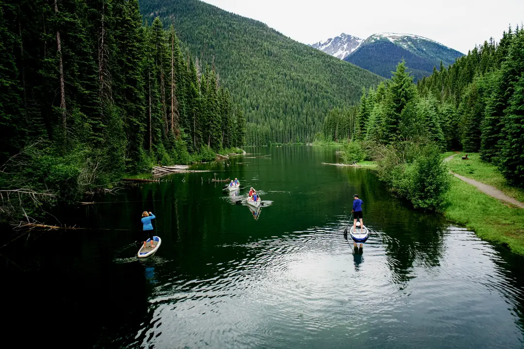 Des gens pratiquent le paddle sur une rivière sereine dans le parc Manning