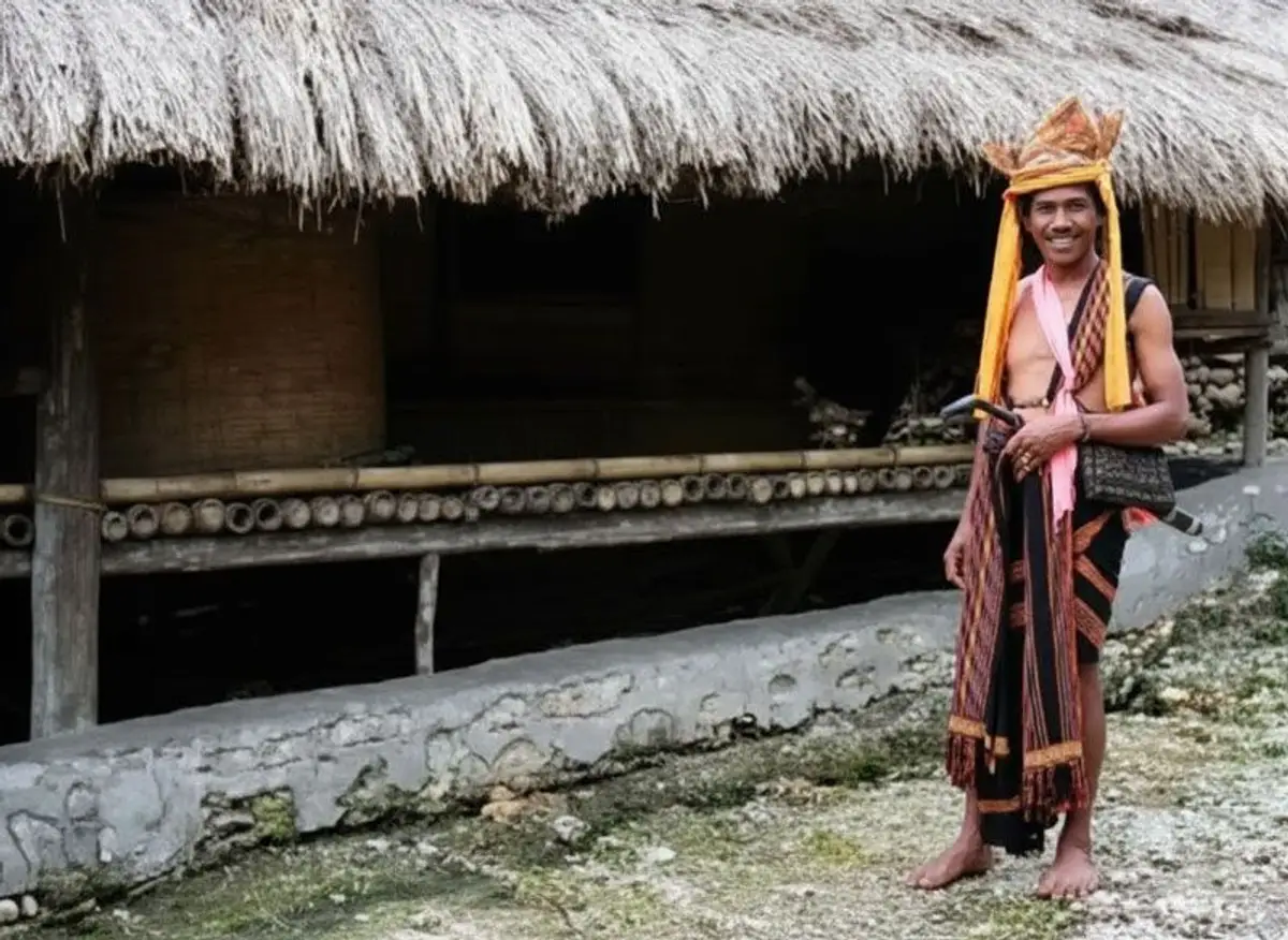 Einheimischer aus Waikabubak steht vor einer Holzhütte