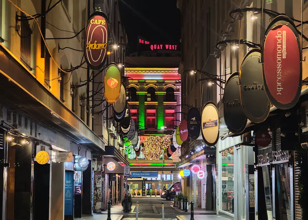 Explorez la vie nocturne animée et colorée de la ruelle du CBD de Melbourne, ornée de panneaux et de lumières vibrants.jpg