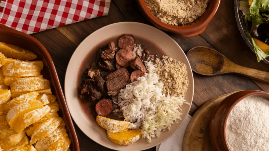 Feijoada brésilienne authentique servie avec farofa, oranges et salade