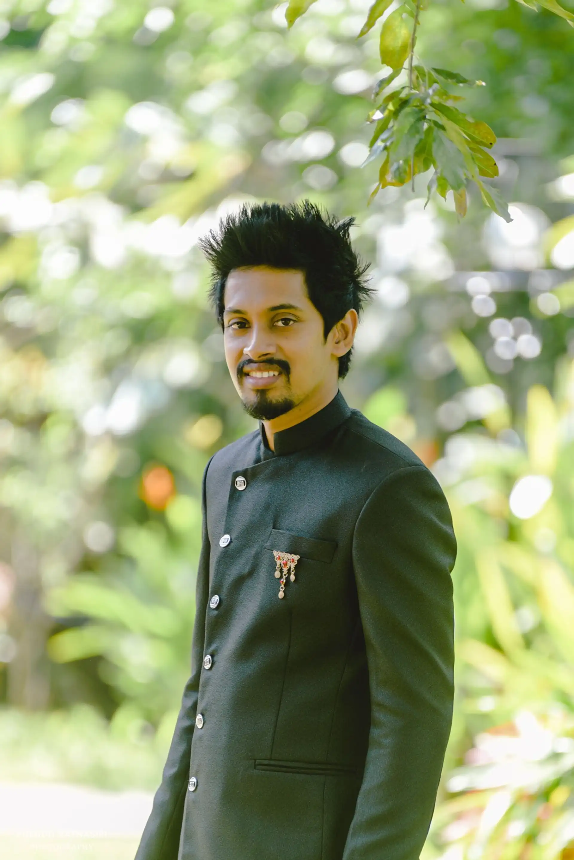 Portrait de Gayan, General Manager et responsable informatique de Shanti Travel à Colombo, souriant au cœur d'une nature verdoyante au Sri Lanka.
