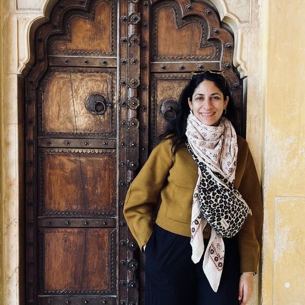 Sanjee devant une porte lors d'un voyage culinaire en Inde