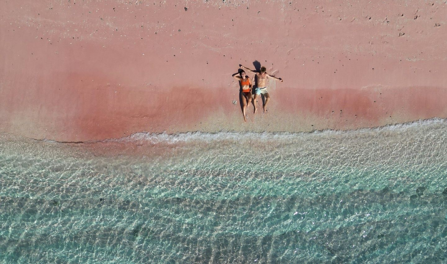 Voyage en Indonésie, Flores : Couple de farniente sur la plage rose de Komodo